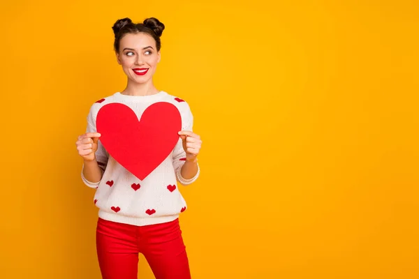 Foto di bella signora tenere il cuore di carta dimostrare idea creativa data cartolina invito indossare bianco rosso cuori modello stampa maglione pantaloni isolato giallo colore sfondo — Foto Stock