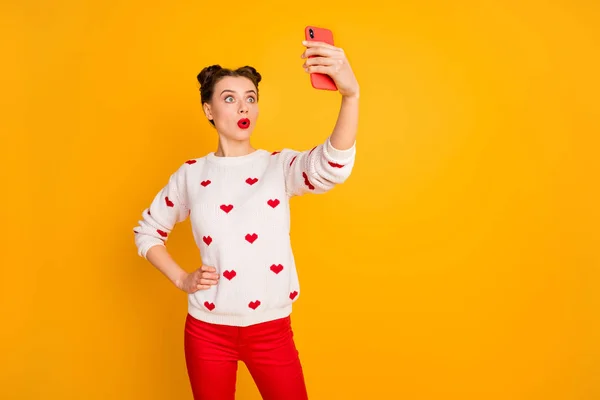 Фотографія досить переляканої леді тримає телефонні руки, приймаючи селфі, що розмовляють друзями скайпу, слухати погані новини, носити серця візерунок білий пуловер червоні штани ізольовані жовтий колір фону — стокове фото