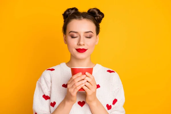 Closeup foto de bela senhora segurando quente café bebida copo olhos fechados desfrutar agradável cheiro emocional desgaste corações padrão branco vermelho suéter isolado cor amarela fundo — Fotografia de Stock