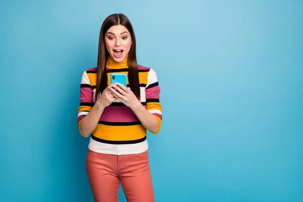 Portrait of astonished funky girl use smart phone get social media notification impressed scream wow omg wear stylish red autumn fall outfit isolated over blue color background — 스톡 사진