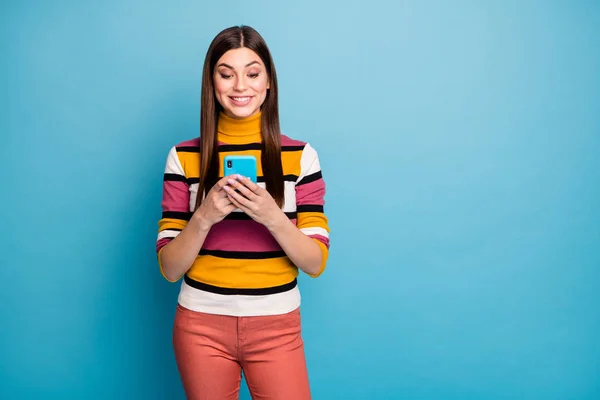 Portret van positief vrolijk meisje gebruik smartphone lees sociale netwerk informatie delen opmerkingen feedback dragen stijlvolle rode trui geïsoleerd over blauwe kleur achtergrond — Stockfoto