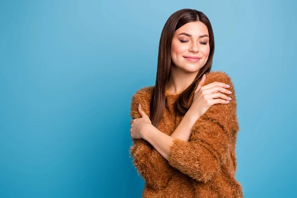 Retrato de chica alegre tranquila abrazo a sí misma disfrutar cálido suéter mullido ojos cerrados usar ropa cómoda aislado sobre fondo de color azul — Foto de Stock