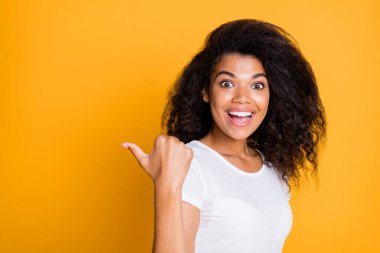 Photo of astonished excited ecstatic cute nice girlfriend expressing positive cheerful emotions on face in white t-shirt pointing at empty space with thumb isolated bright color background clipart