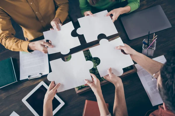 Boven hoge hoek bekijken foto van gerichte freelancer mensen zitten tafel bureau samenvoegen papier puzzel stukken elementen vertrouwen ondersteuning bedrijf carrière coaching concept op werkplek — Stockfoto