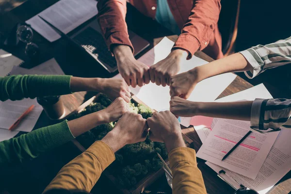 Arriba arriba alto ángulo vista recortado foto marketers socios poner puños juntos círculo redondo apoyo start-up objetivos teambuilding formación concepto por encima de mesa escritorio lugar de trabajo —  Fotos de Stock