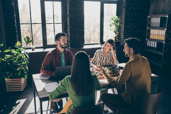 Fagerfarne forretningsfolk haier, spesialister på haier, finansmenn i uformelle klær som diskuterer IT-kontrakt på moderne industrielt lofts- og mursteinsverksted – stockfoto