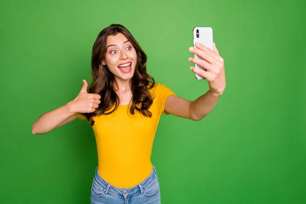 Portrait of her she nice attractive lovely charming pretty childish cheerful cheery wavy-haired girl taking selfie showing thumbup isolated on bright vivid shine vibrant green color background — Stock Photo, Image