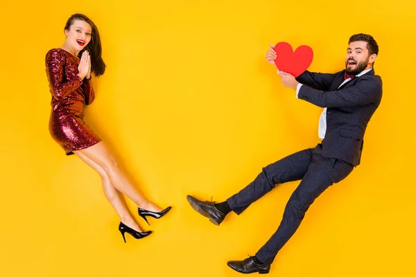 Top above high angle view full body profile side photo of two people romance date man catch red big paper card heart woman amazed wear suit bowtie lay isolated yellow color background — 스톡 사진