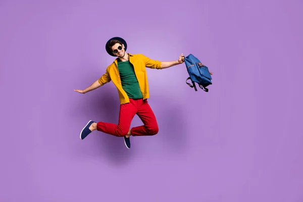 Foto de tamaño completo de chico positivo saltar de la mano como pájaro volar llevar mochila azul casual traje moderno aislado sobre fondo de color púrpura — Foto de Stock