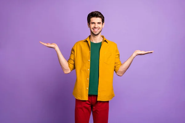 Foto von trendigen fröhlichen positiven Mann lächelt zahnlos in roten Hosen Hose mit Stoppeln isoliert halten leeren Raum violett pastellfarbenen Hintergrund — Stockfoto