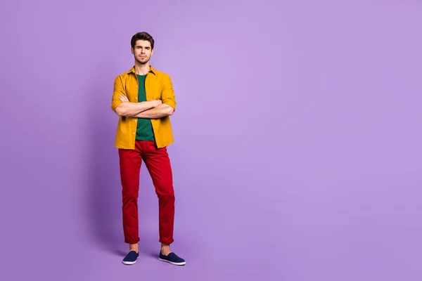 Фотография в полный рост, на которой серьезный уверенный мужчина с скрещенными руками пристально смотрит на вас в обуви на фоне фиолетового цвета — стоковое фото