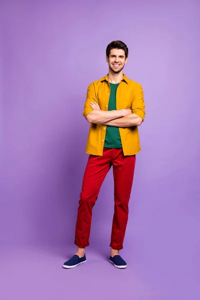 垂直フル長ボディサイズ写真のおもちゃのビーミングハンサムな男で赤いパンツの履物で腕を交差分離された紫色のパステルカラーの背景 — ストック写真
