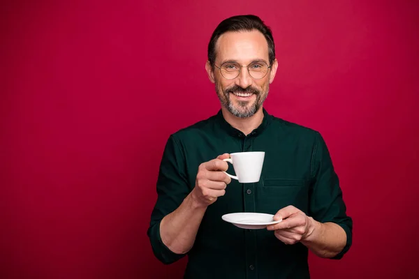 Photo de joyeux positif bel homme attrayant sourire dents tenant tasse de thé boire isolé fond de couleur vive — Photo