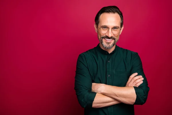 Photo d'un homme joyeux et confiant, souriant avec les bras croisés, souriant, dents isolées dans des lunettes sur fond de couleur rouge vif — Photo