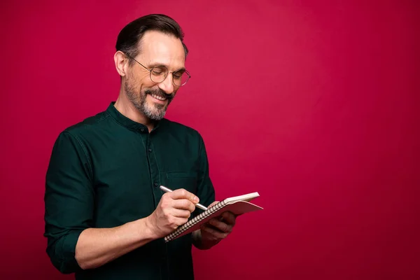 Turned photo of cheerful handsome attractive man noting down the recipe of his success standing near empty space isolated vivid color background — Stock Photo, Image