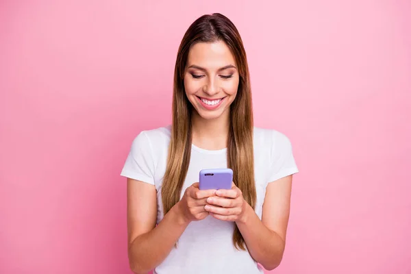 Welke foto is het beste. Foto van mooie dame met telefoon handen sms 'en vrienden verzenden van nieuwe net gemaakte selfies dragen casual wit t-shirt geïsoleerde roze kleur achtergrond — Stockfoto