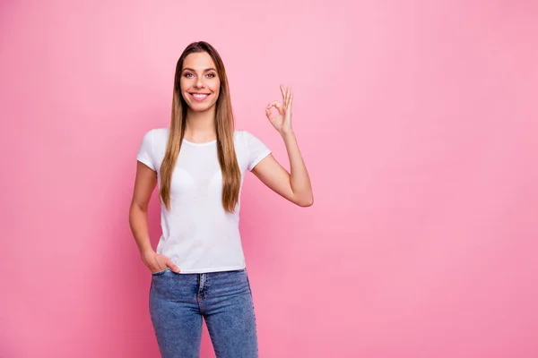 Foto de incrível senhora atraente mostrando símbolos okey mãos expressando acordo dente encantador sorrindo desgaste casual branco t-shirt jeans isolado cor rosa fundo — Fotografia de Stock