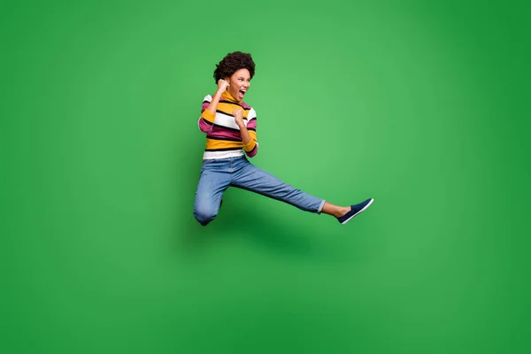 Foto de comprimento total de engraçado louco afro americano menina saltar prática outono esportivo kickboxing pontapé pernas punhos luta inimigo copyspace desgaste brilho bela roupa isolado cor verde fundo — Fotografia de Stock