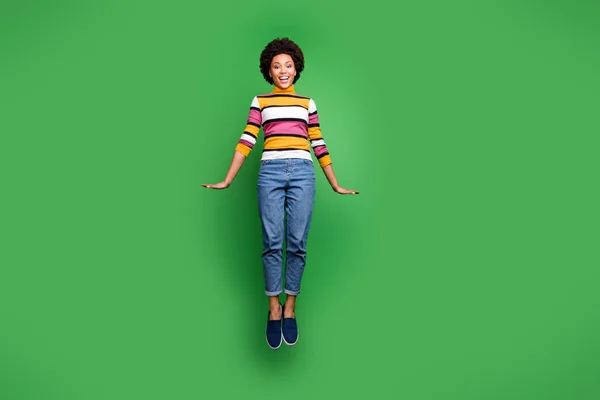 Neşeli Afro-Amerikan kız atlayışının tam boy fotoğrafı. Sonbaharın tadını çıkarın. Parlak arka planda izole edilmiş şık kıyafetler giyin. — Stok fotoğraf