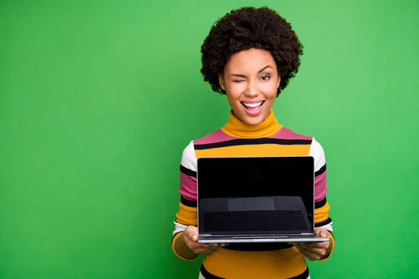 Portrait of positive afro american girl hold netbook show touch screen merekomendasikan teknologi digital modern memakai pakaian bergaya kasual yang terisolasi di atas latar belakang warna hijau — Stok Foto