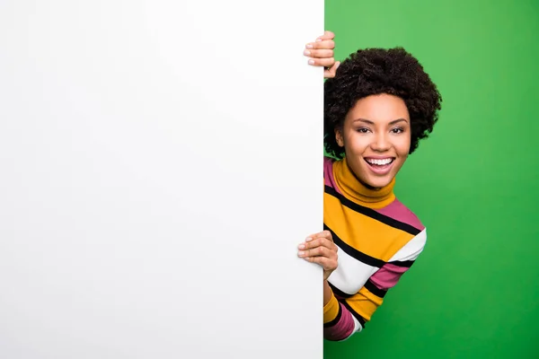 Φθηνή διαφήμιση. Φωτογραφία από το όμορφο σκούρο δέρμα κυματιστή κυρία ενθουσιασμένοι διάθεση παρουσιάζοντας μεγάλο λευκό κενό χώρο αφίσα για τα νέα φορούν casual ριγέ πουλόβερ απομονωμένο πράσινο χρώμα φόντο — Φωτογραφία Αρχείου