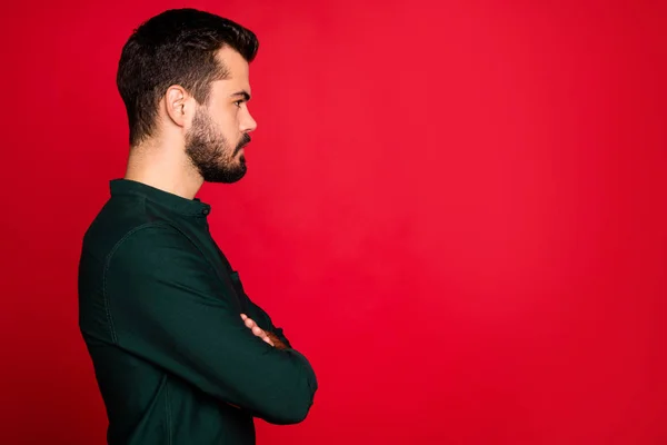 Porfile lado de la foto de tipo masculino brutal cruzan las manos mirada copyspace grave usar ropa moderna aislada sobre fondo de color rojo —  Fotos de Stock