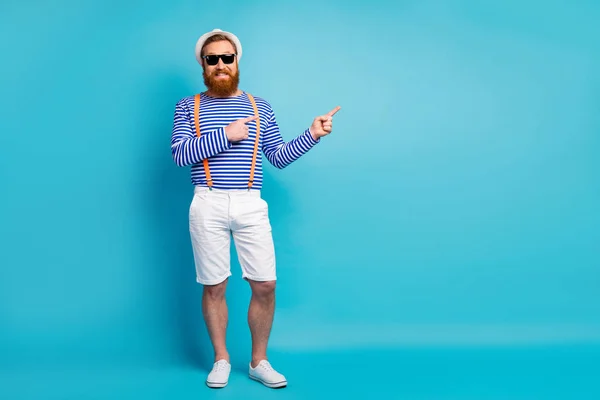 Tam boy fotoğraf pozitif sakallı adam teşvikçi yaz seyahati işaret parmağı reklamını yap turuncu çizgili yelek seç mavi renkli arka plan — Stok fotoğraf