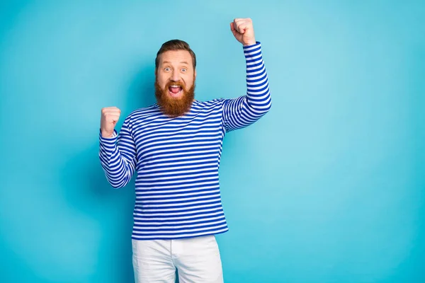 Портрет веселого позитивного человека выиграть спортивные соревнования лотереи впечатлил поднять кулаки кричать да носить хорошую одежду туалета изолированы на синем фоне цвета — стоковое фото