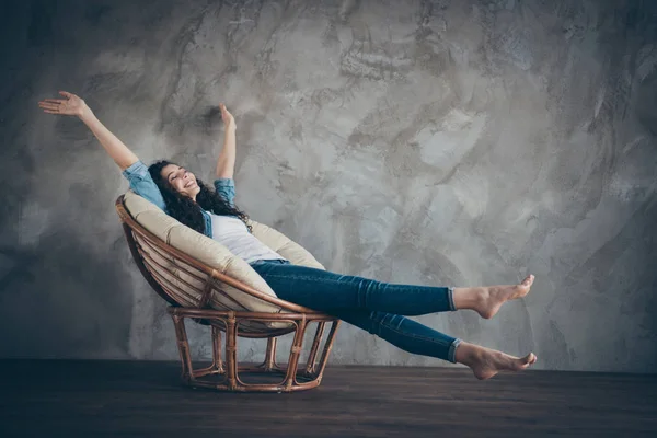 Perfil vista lateral retrato de ella ella agradable atractivo femenino alegre alegre alegre soñadora ondulada chica de pelo ondulado tumbado en sillón descansando estiramiento divertirse en el moderno loft interior de estilo industrial — Foto de Stock