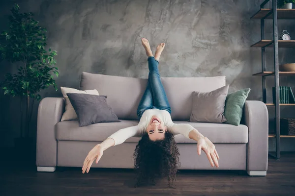 Onun güzel, çekici, çekici, çekici, neşeli, neşeli, dalgalı saçlı kızın portresi modern endüstriyel ahşap tarzı oturma odasında divanda uzanırken eğleniyor. — Stok fotoğraf