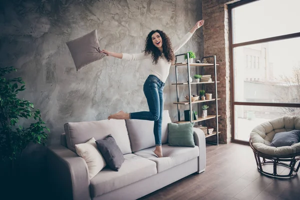 Full length body size view of her she nice attractive lovely slim fit thin slender cheerful wavy-haired girl having fun dancing on divan in modern loft industrial brick style interior apartment — стоковое фото