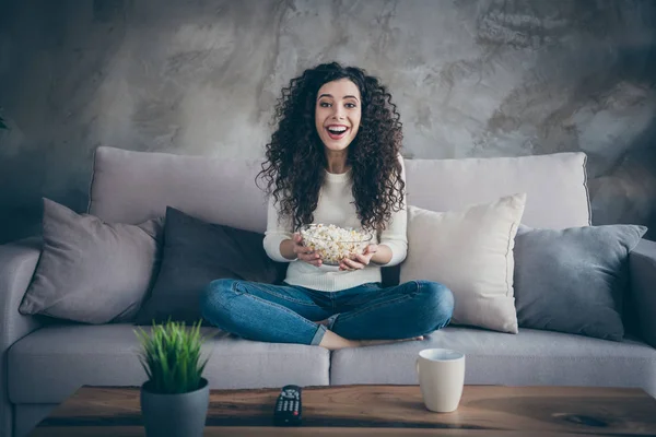 Portrait of her she nice-looking attractive charming lovely cheerful cheery glad wavy-haired girl sitting on divan eating corn at modern industrial loft interior style room — 스톡 사진