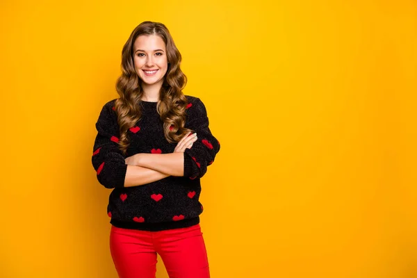 Foto de muito ondulado longo penteado senhora auto-confiantemente cruzando braços bom humor desgaste quente preto vermelho corações padrão camisola calças isoladas cor amarela fundo — Fotografia de Stock