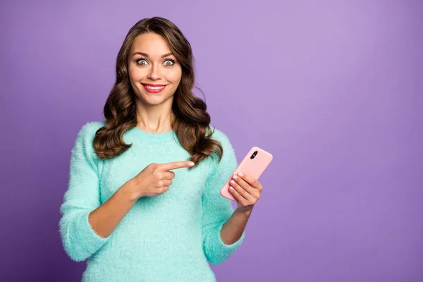 Foto van grappige mooie dame houd telefoon handen geven vinger op het scherm van het apparaat adviseren koele smart phone verkoop dragen casual pastel pluizig fuzzy trui geïsoleerde paarse kleur achtergrond — Stockfoto