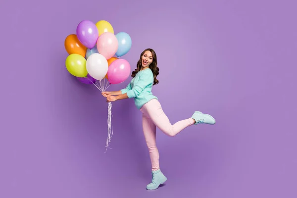 Full body photo of cheerful feminine girl hold many baloons enjoy festive woman day event scream wear turquoise pastel sweater pink footwear isolated over purple color background — 스톡 사진