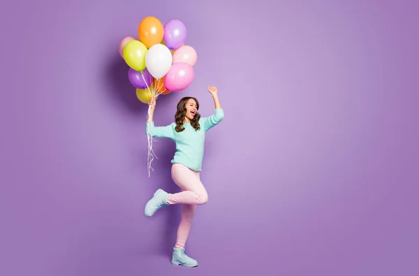 Profilo completo del corpo foto di bella signora divertente tenere molti palloncini d'aria colorati celebrare partito inizio indossare maglione fuzzy pantaloni rosa scarpe pastello isolato colore viola sfondo — Foto Stock