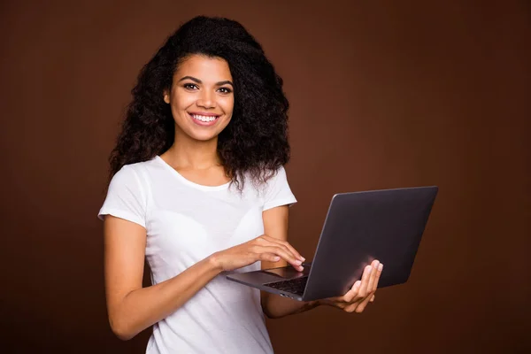 Retrato de niña afro-americana alegre positiva uso de chat de computadora con amigos desgaste traje de estilo casual aislado sobre fondo de color marrón —  Fotos de Stock