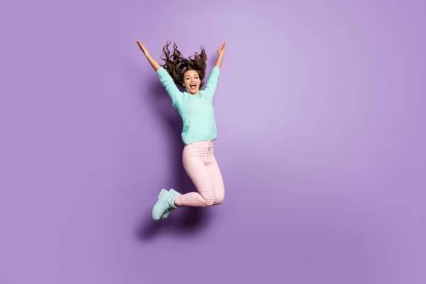 Foto de longitud completa de la señora funky salto de altura buen humor regocijo lanzar peinado vuelo fin de semana desgaste difuso suéter rosa pantalones pastel calzado aislado color púrpura fondo — Foto de Stock