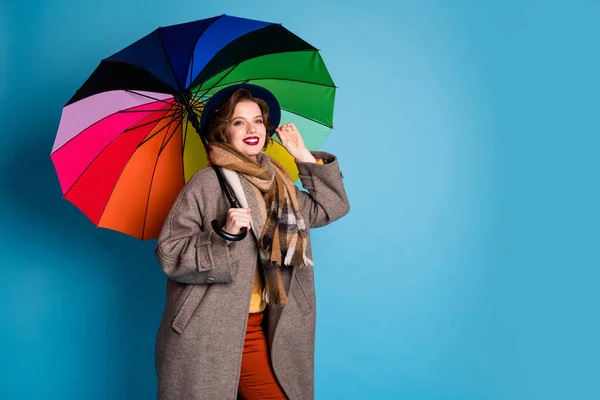 Photo of pretty traveler lady hold kolorowy parasol spacery ulicą nosić stylowy casual długi szary płaszcz sweter pomarańczowy spodnie kapelusz szalik kratę odizolowany niebieski kolor tło — Zdjęcie stockowe