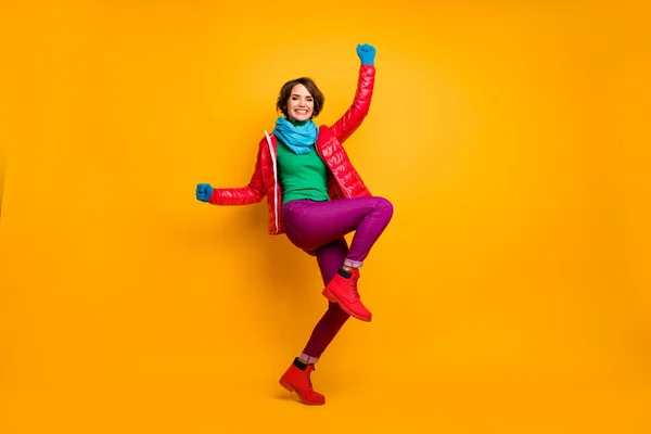 Full size profile photo of funky lady raise hands leg crazy millennial person wear casual red coat blue scarf gloves turtleneck trousers footwear isolated yellow color background — Stock Photo, Image