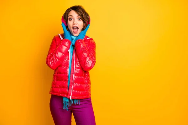 Photo of funny impressed lady enjoy modern earmuffs warmth open mouth wear stylish casual red overcoat blue scarf pink pants isolated yellow color background — 图库照片