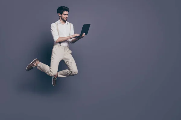 Pełnowymiarowe zdjęcie zarozumiałego pracownika start-up skok pracy jego komputer wyszukiwania rabaty sprzedaży nosić nowoczesny modny strój odizolowany na szarym tle kolor — Zdjęcie stockowe