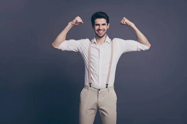 Ikke glem treningen. Foto av macho-forretningsmann reiser to store biceps kledd i hvite skjorte-beige bukseseler isolert grå bakgrunn – stockfoto