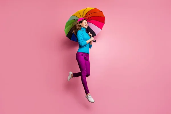 Volledige lengte profiel zijkant foto van vrolijk meisje springen hold glans regenboog paraplu genieten vrije tijd kijken copyspace dragen stijlvolle kleding geïsoleerd over roze kleur achtergrond — Stockfoto