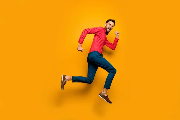 フルサイズプロフィール写真の面白い男ジャンプ高アップラッシュ黒金曜日ショッピングセンター着用トレンディーな赤シャツ弓ネクタイパンツシューズ服孤立黄色色背景 — ストック写真