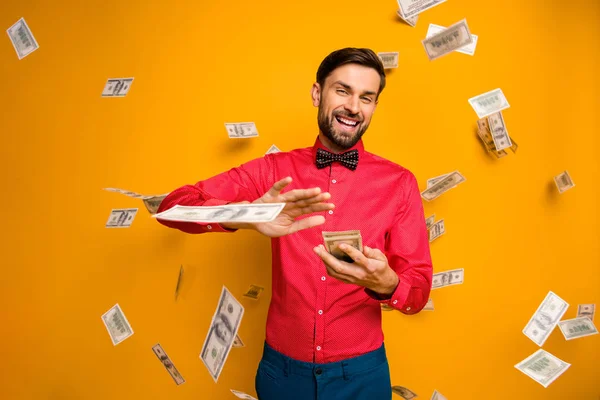 Photo of crazy funny guy hold fan of money bucks waste jackpot throw away banknotes money falling wear trendy red shirt bow tie clothes isolated yellow color background — Stock Photo, Image