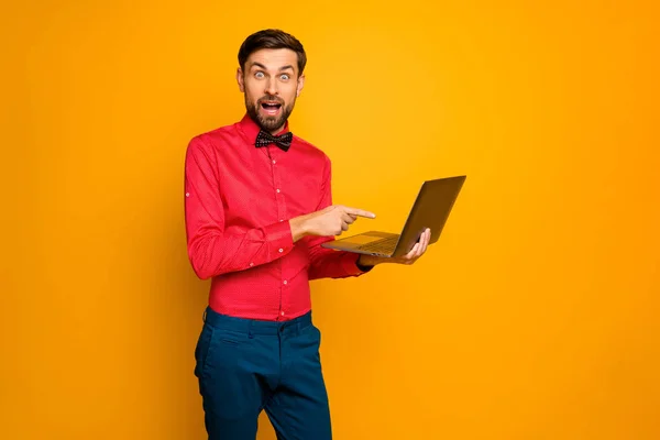 Foto de louco animado cara de negócios segurar notebook ler e-mail novo projeto chefe aprovação direta dedo tela desgaste moda vermelho camisa arco gravata azul calças isoladas cor amarela fundo — Fotografia de Stock