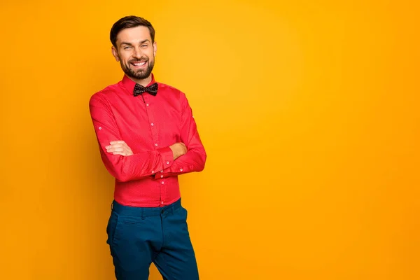 Photo of attractive business guy good mood arms crossed friendly person reliable worker wear stylish red shirt with black bow tie blue pants isolated yellow color background — Zdjęcie stockowe