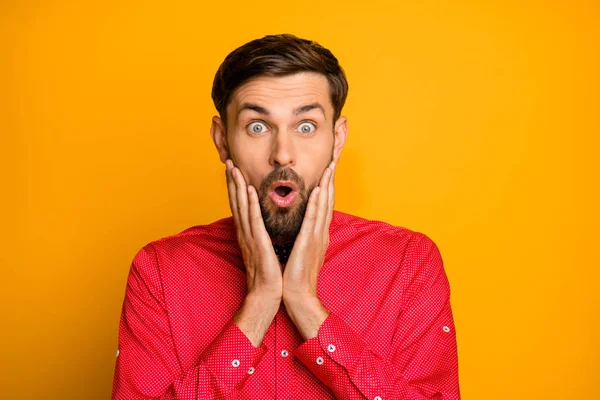 Photo of funny macho guy hold arms on cheeks good mood enjoy unexpected surprise open mouth wear stylish red shirt with black bow tie isolated yellow color background — Stok fotoğraf