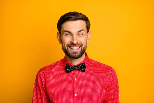Foto van verbazingwekkende grappige macho guy goed humeur vriendelijke stralen glimlachen show man dragen stijlvolle rode shirt met gestippelde zwarte strik geïsoleerde gele kleur achtergrond — Stockfoto